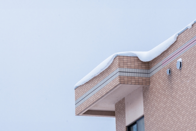 屋根のふちに雪庇ができて落雪しそうな写真