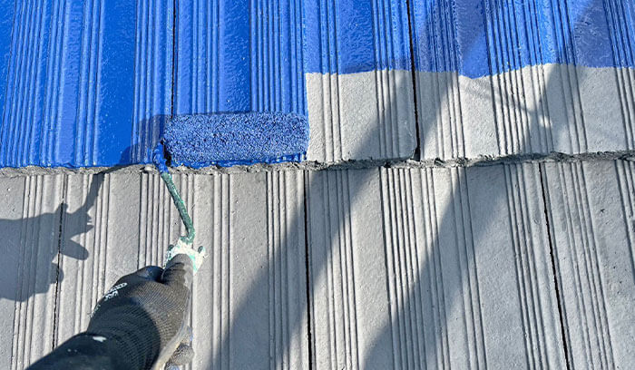 スレート屋根に塗装をしている様子