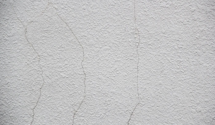 モルタル外壁の表面に細いひび割れがある様子