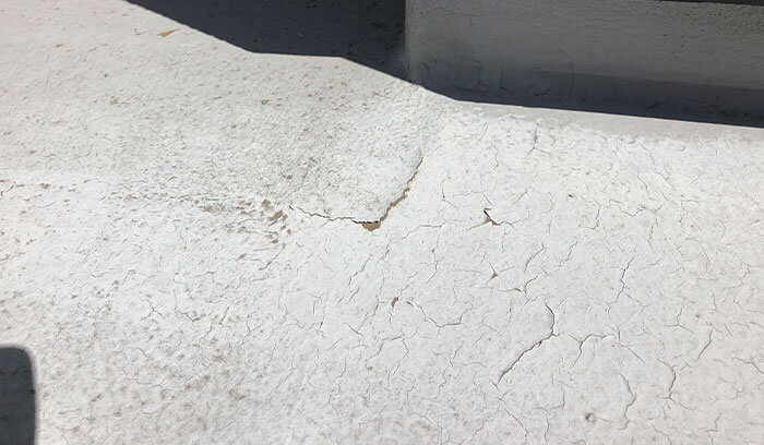 ベランダ床にひび割れが発生し劣化している様子