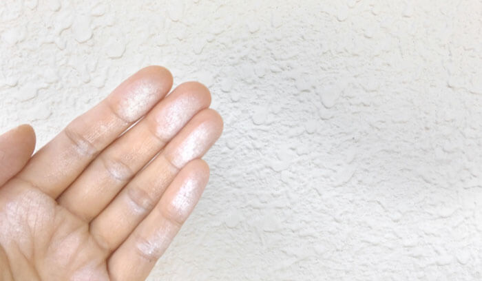 外壁を触って白い粉がついた様子（チョーキング現象）