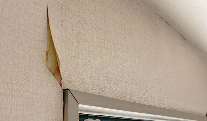 雨漏りが起きて室内の壁紙が剥がれている様子