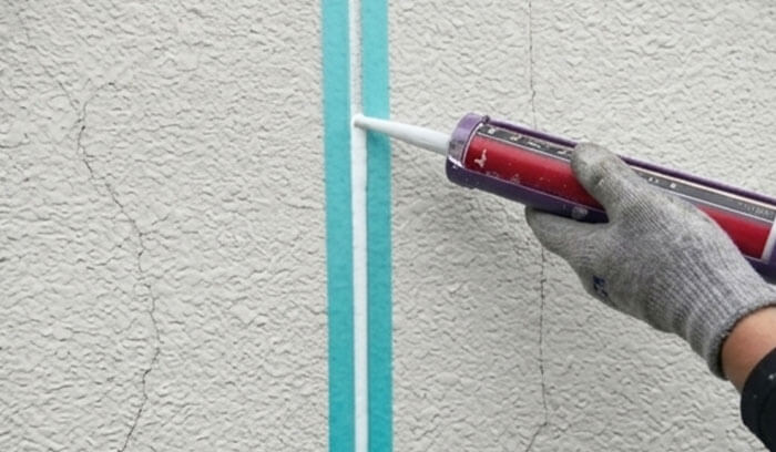 モルタル外壁のひび割れをシーリングで補修する様子
