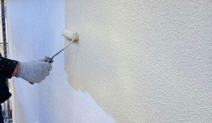 モルタル外壁に塗装を施している風景