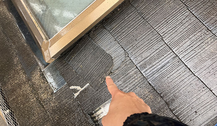 屋根材のズレている部分を指さす様子