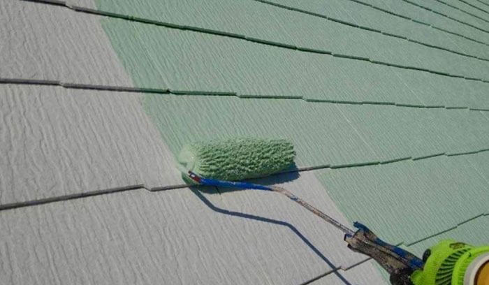 屋根に塗装をしている様子