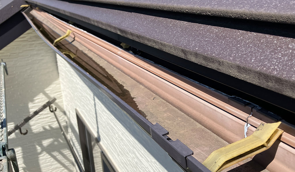 金具が破損し大きく歪んだ雨どいの写真