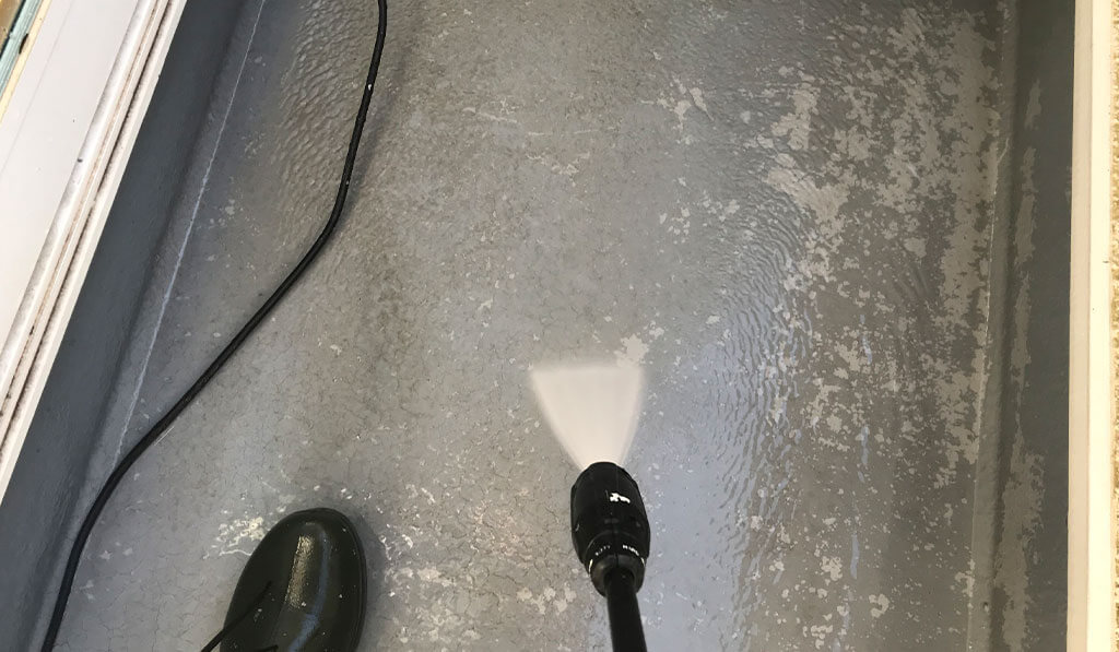 ベランダの床を高圧洗浄している様子