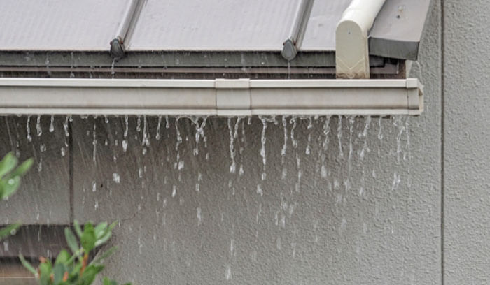 ゲリラ豪雨により雨どいから水が溢れている様子